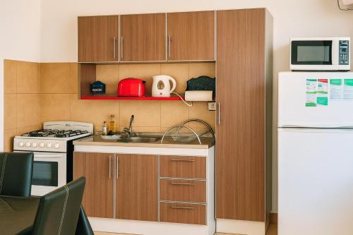 a small kitchen with a sink and a refrigerator at Complejo STC SomoS in Colón