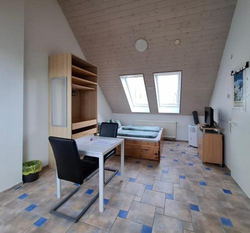 a room with a table and chairs and a bed at Dachgeschoss Harbour Apartments Höri in Moos