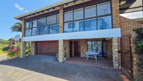 a house with a large window and a patio at Guernsey Flat in Port Shepstone