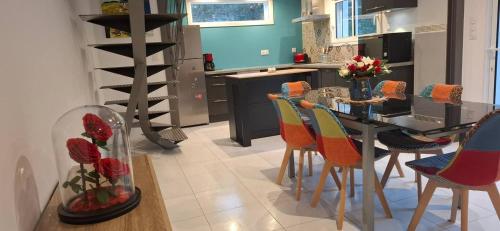 a kitchen with a table and chairs with a vase of flowers at Le Vallon du Garn - Gîte en pleine nature in Laval-Saint-Roman