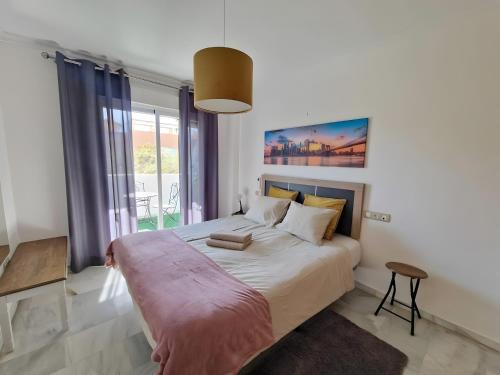 een slaapkamer met een groot bed en een groot raam bij Centrally Located Penthouse A103 in Las Lagunas Mijas