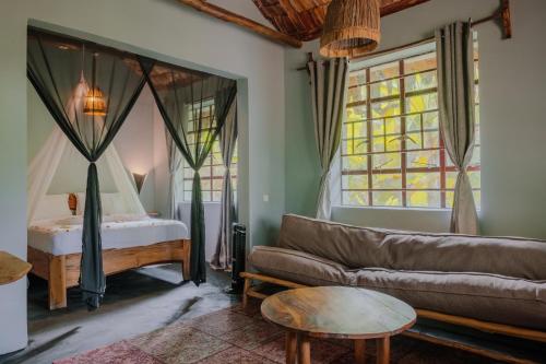 a living room with a couch and a bed at The Jungle Pearl Resort in Mto wa Mbu