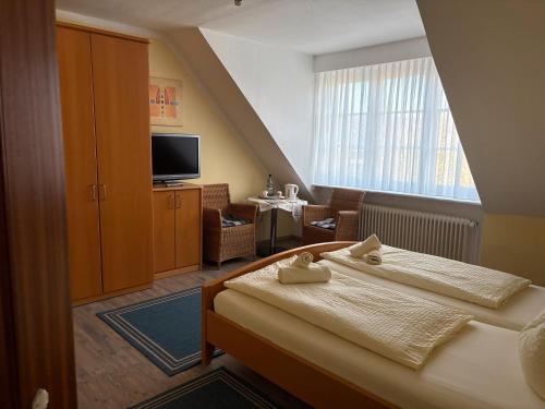 ein Hotelzimmer mit zwei Betten und einem Fernseher in der Unterkunft Hotel-Restaurant Nord Stuv in Cuxhaven