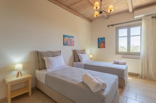 a bedroom with two beds and a window at Elia Villas in Riglia