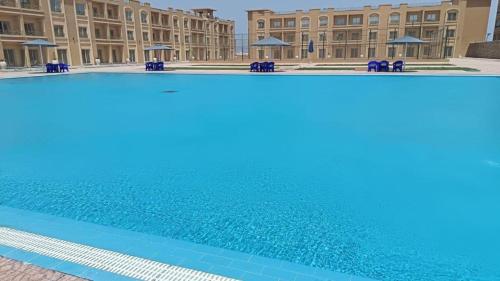 a large swimming pool in front of a building at Bay View Sahl Hasheesh Chalet in Hurghada