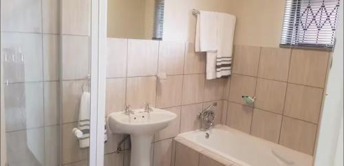 a bathroom with a sink and a toilet and a tub at Peaceful Casa in Kempton Park