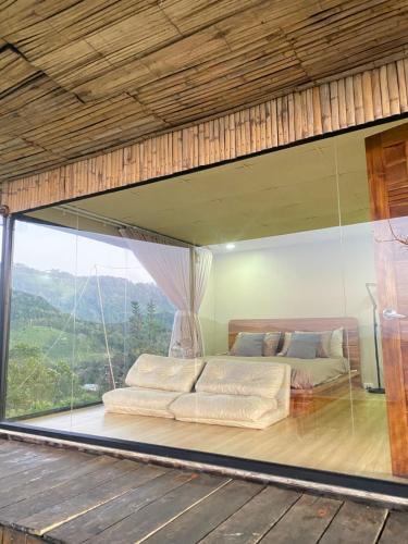 een bed in een kamer met een groot raam bij แล้วแต่เพื่อนวิลล่า in Ban Huai Khai