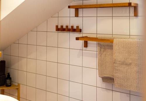 a bathroom with white tiled walls and wooden shelves at Apartment ILWA in Schladming