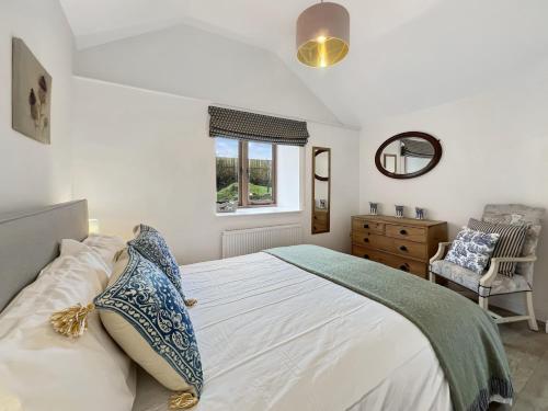 a bedroom with a bed and a window and a chair at Westlands Brendon Hill in Treborough