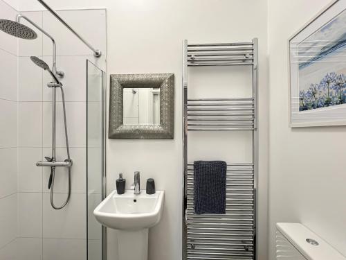 a white bathroom with a sink and a shower at Westlands Brendon Hill in Treborough