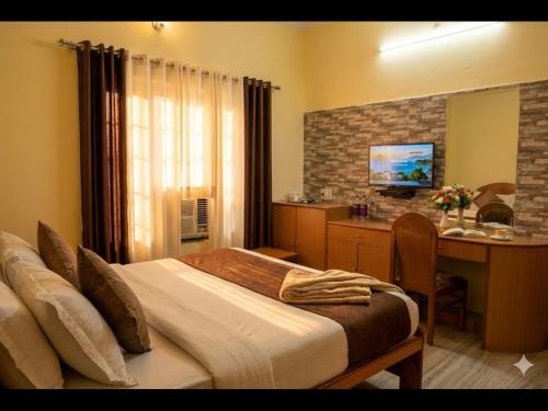 a bedroom with a bed and a desk with a computer at Bagiya Resort in Sīkar