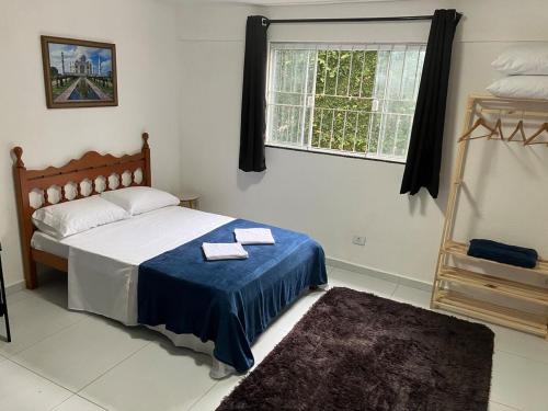 a bedroom with a bed with two towels on it at Panama 90 - Studio - Região Central in Poços de Caldas