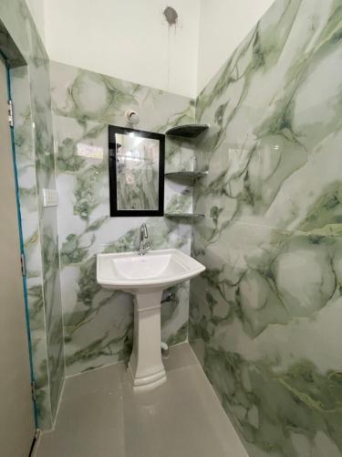a bathroom with a sink and marble walls at Karma Stay 2BHK apartments in Jaigaon