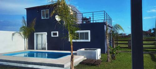una casa azul con piscina al lado de un árbol en AZUL Casa De Campo, en Esquina