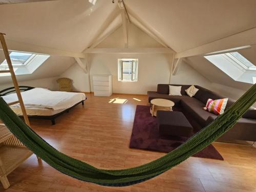 a hammock in a room with a bed and a couch at T1 Gästehaus Wohlen AG in Wohlen