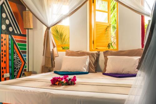 a bed in a room with flowers on it at Kaya Imani in Msambweni