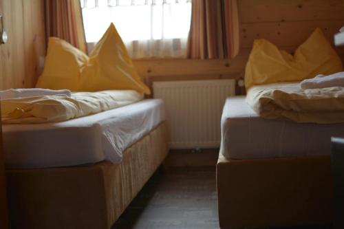 a room with two beds with yellow pillows on them at Chalet Auhof in Flachau