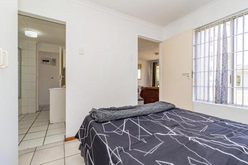 a bedroom with a bed and a bathroom at Hermanus Beach Club in Hermanus