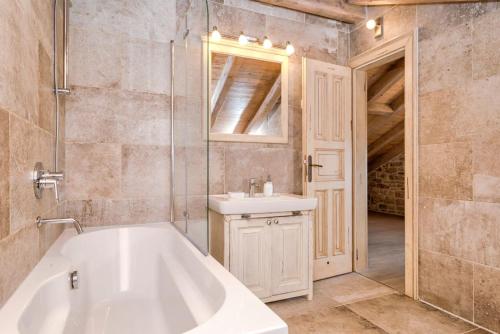 ein Badezimmer mit einer weißen Badewanne und einem Waschbecken in der Unterkunft Old Town Villa Hvar in Basina