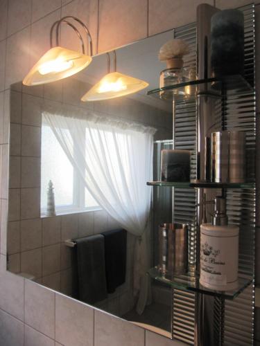 a mirror in a bathroom with a window at Pebble Stone House Bed & Breakfast in Swakopmund