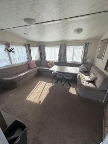 a living room with a couch and a table at Sunnymede D1 - Hot Tub Caravan - Sleeps 10 - Fantasy Island, Ingoldmells - Meadow Lakes Caravan & Lodge Hire in Ingoldmells