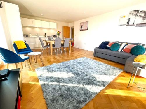 a living room with a couch and a rug at Modern Town Centre Apartment in Chelmsford