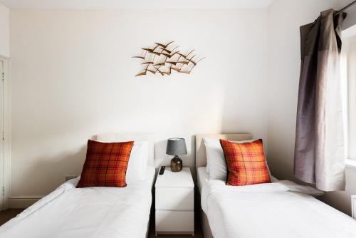 two beds sitting next to each other in a room at Garden flat near Ealing Broadway in London