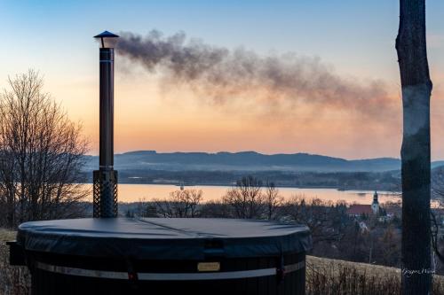 a smoke stack next to a body of water at Rest Hill -Domek z balią i sauną - Everslow in Sosnówka