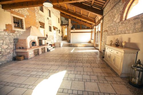 a large room with a stone building with a stove at Ca' Maiolo - Villa con piscina in Montecchio Maggiore