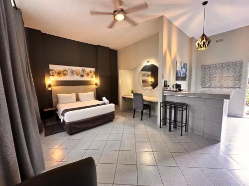 Un dormitorio con una cama y un escritorio y una cocina. en N1 Hotel Samora Machel Harare, en Harare