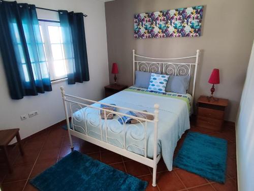 a bedroom with a white bed and blue rugs at Marmequer in Almograve