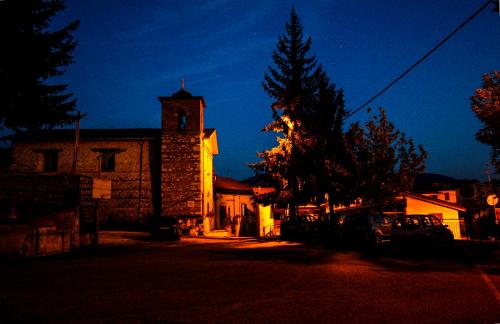 a church with a clock tower on a street at Casa Vacanze Antico Poggio in Poggio San Giovanni