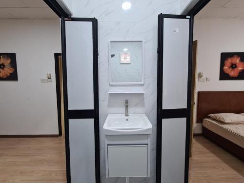 Un baño con lavabo y una cama en una habitación. en Safaira Homestay, en Alor Setar