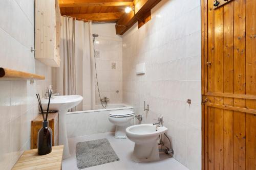 a white bathroom with a toilet and a sink at Mansarda di charm Valli di Borzago in Mortaso