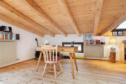 a wooden desk with a chair in a room at Mansarda di charm Valli di Borzago in Mortaso
