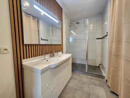 a bathroom with a white sink and a shower at Le Plaisance de Mérignac in BOD