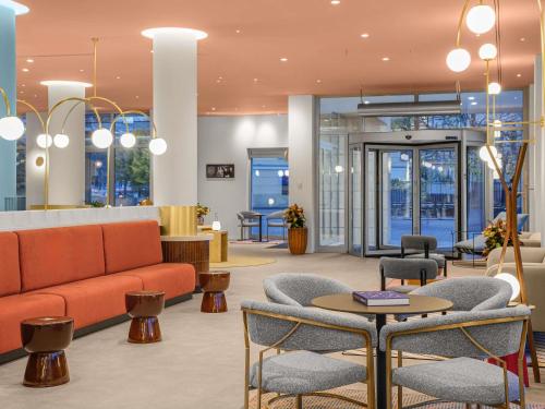 eine Lobby mit einer Couch, Stühlen und einem Tisch in der Unterkunft Hotel Lycium Debrecen - Handwritten Collection in Debrecen