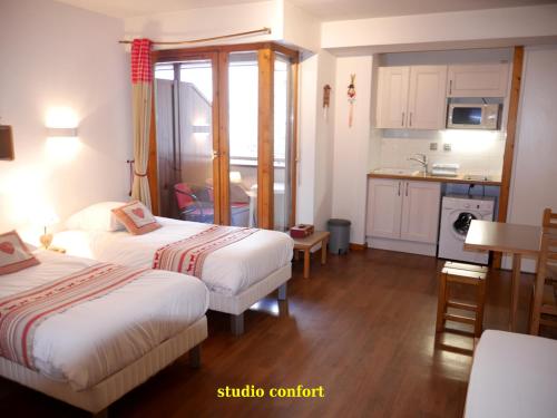 Una habitación de hotel con dos camas y cocina. en Le Grand Chalet - Le Studio, en Brides-les-Bains