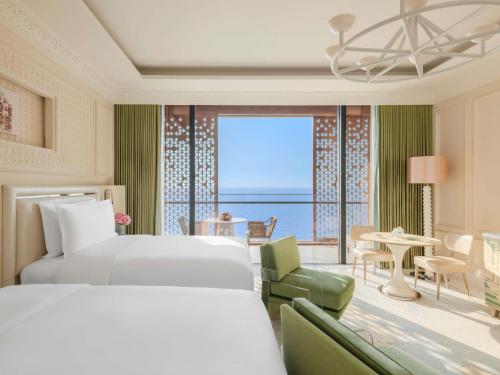 a hotel room with two beds and a view of the ocean at Raffles Jeddah in Jeddah