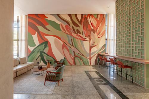 a living room with a colorful mural on the wall at Intercity Porto Alegre Praia de Belas in Porto Alegre