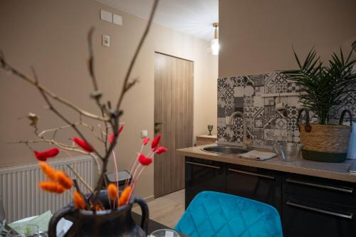 a kitchen with a table and a vase with flowers at Pipera Studio Apartment in Voluntari