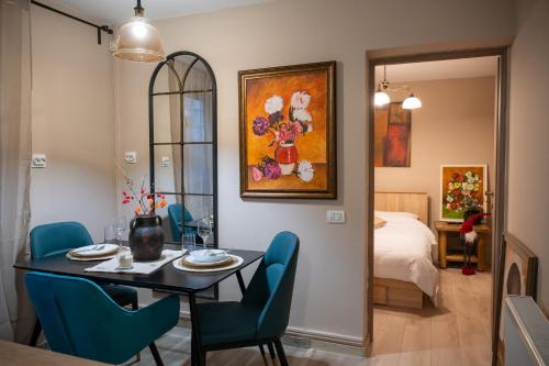 a dining room with a table and chairs and a bedroom at Pipera Studio Apartment in Voluntari