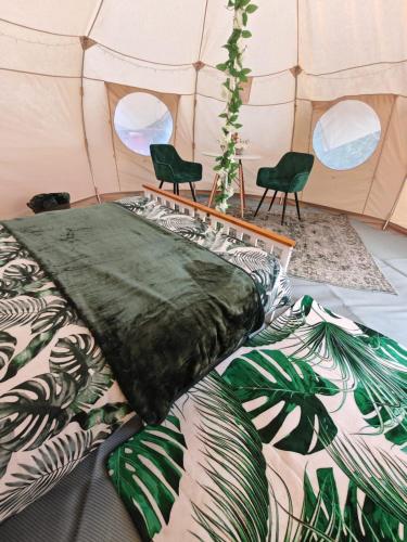 a room with a bed and chairs in a tent at The Shire Glamping in Kearsney