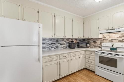 a kitchen with white cabinets and a refrigerator at AV2-3E - Don't Blink in Croatan Shores