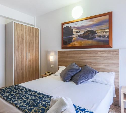 een slaapkamer met twee bedden en een schilderij aan de muur bij Hotel San Marino in Riccione