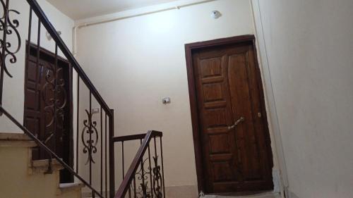 einen Flur mit Holztür und Treppe in der Unterkunft Dreams House in Luxor
