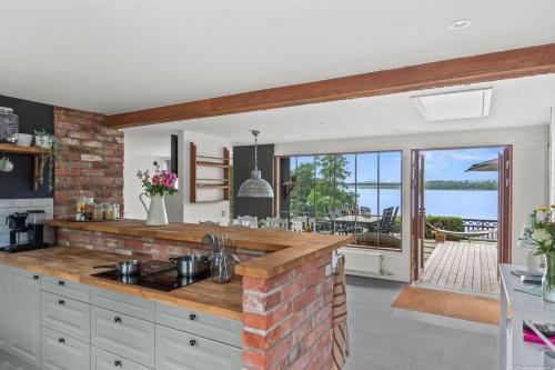 cocina con pared de ladrillo y encimera en Sjöutsikt Sövde, en Sövde