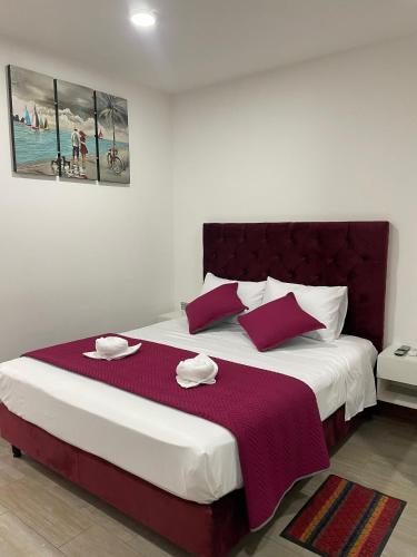 a bedroom with a large bed with red and white pillows at Lindo Apart - Churrasquera y Patio Privado in Santa Cruz de la Sierra