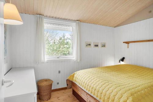 a bedroom with a yellow bed and a window at 3004-Stege-Paelen-21 in Stege