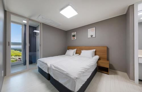 Una cama o camas en una habitación de The 강릉 오션스테이 first
